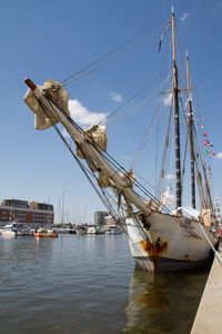 Sailboats moored in sea against sky