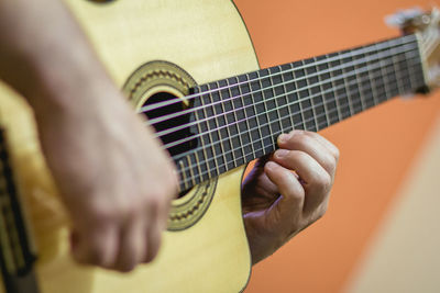 Cropped image of man playing acoustic guitar