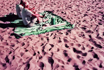 High angle view of woman lying on sand