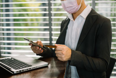 Midsection of businessman using mobile phone