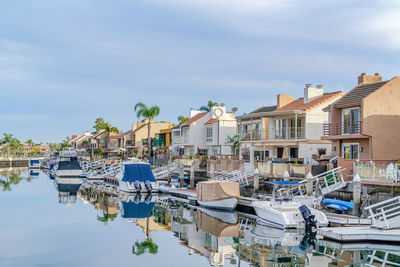 Boats moored at harbor against buildings in city