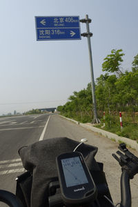 Road sign against sky