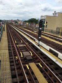 Railroad tracks in city against sky