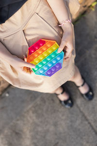 High angle view of woman holding multi colored toy