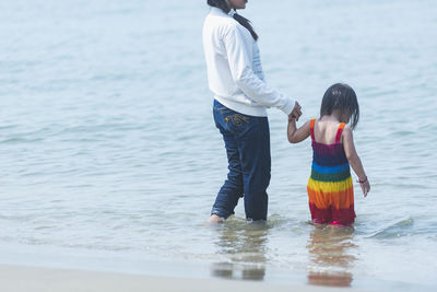 Rear view of woman standing in sea