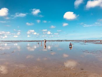 People on beach against sky