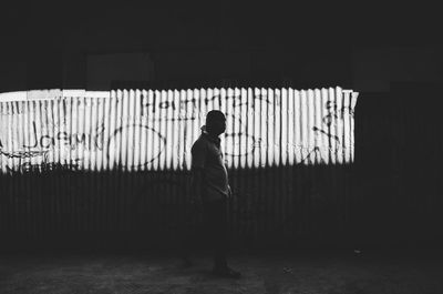 Side view of silhouette man standing against wall