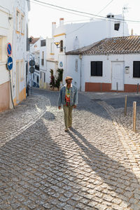 Side view black woman with hat and sunglasses walking on the street