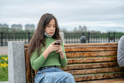 Portrait of young woman sitting on bench