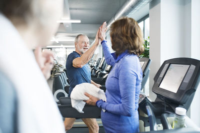 Group of fit seniors on treadmills working out in gym