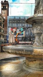 Portrait of woman against buildings in city