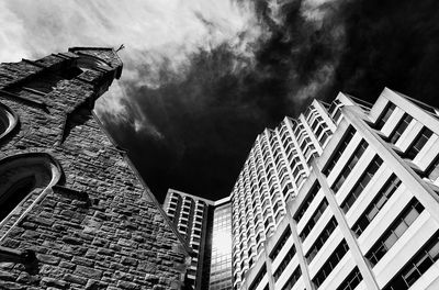 Low angle view of buildings against cloudy sky