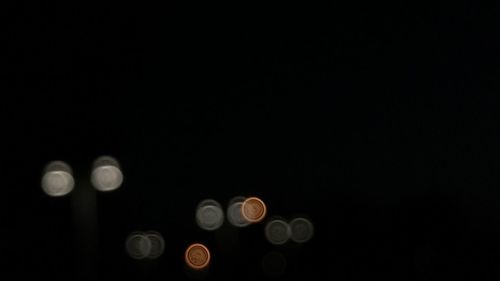 Close-up of illuminated lighting equipment against black background