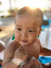 Cute baby boy looking away while licking spoon