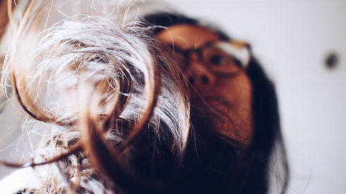 Low angle view of young woman with long hair looking away at home