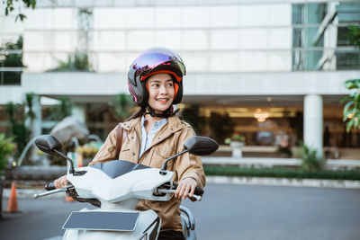 Side view of man riding motorcycle on street