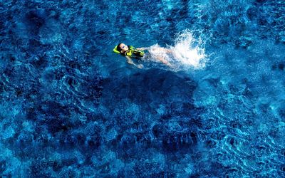 High angle view of boy swimming in sea