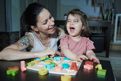 A mother teaching her daughter the letters of the alphabet. concept of learning