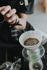 Midsection of woman pouring coffee in cup