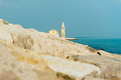 Building by sea against sky