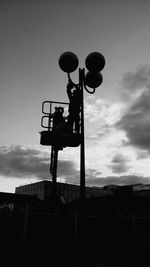 Low angle view of silhouette crane against sky