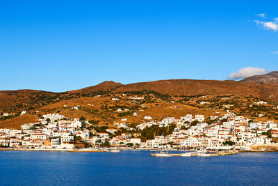 Scenic view of sea and buildings against clear blue sky