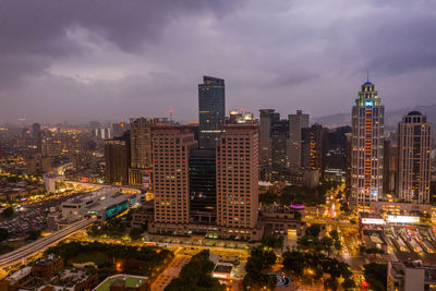 Aerial view of illuminated buildings in city against sky