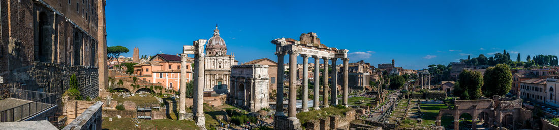 Panoramic view of buildings against blue sky