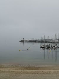 Sailboats in sea against sky