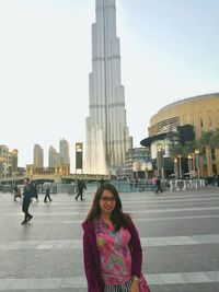 Portrait of woman with city in background