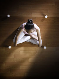 Directly above shot of woman practicing yoga on hardwood floor