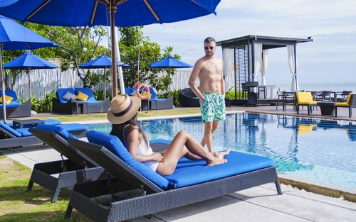 Rear view of woman sitting in swimming pool