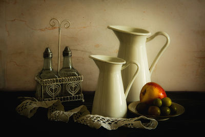 Fruits in jar on table against wall