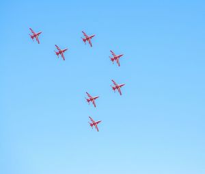 Low angle view of airshow against clear blue sky