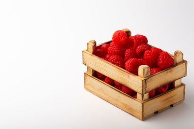 Close-up of strawberries in box against white background