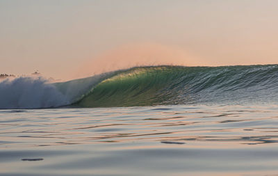 Surface level of sea against sky during sunset