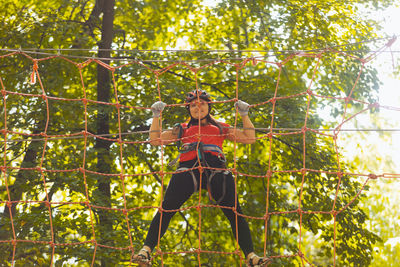 Woman standing by tree in forest