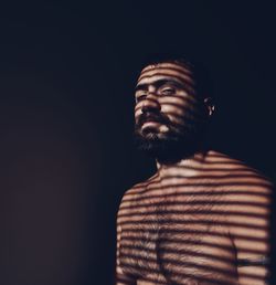 Man looking away against black background