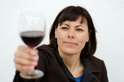 Close-up portrait of a smiling young woman drinking drink