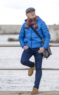 Low section of man standing on railing