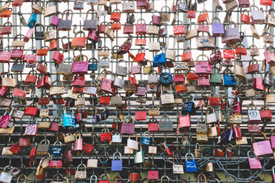 Full frame shot of colorful padlocks attached in fence
