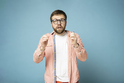 Portrait of man standing against blue background