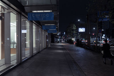 Illuminated street amidst buildings in city at night