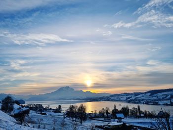 Scenic view of snowcapped mountains against sky during sunset