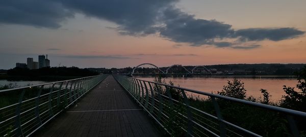 Bridge over river against sky during sunset