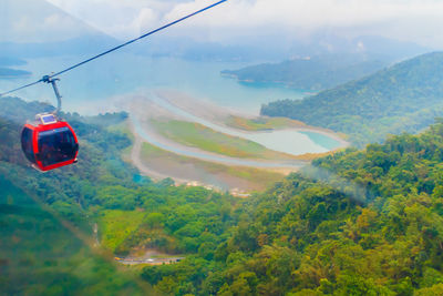 Overhead cable car over mountains against sky