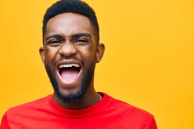 Portrait of young man against yellow background