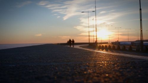 People on beach against sky during sunset