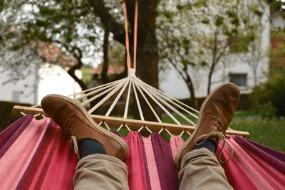 Low section of person relaxing on hammock