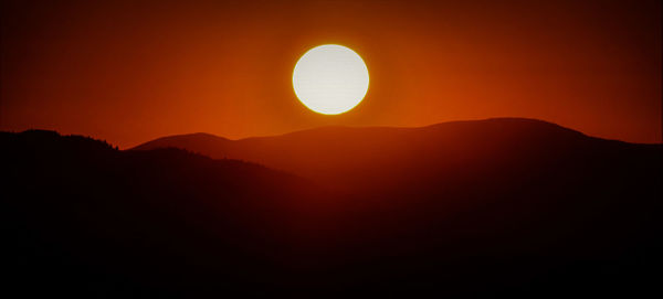 Scenic view of silhouette mountains against sky during sunset